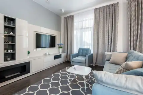 Bright living room with light gray walls, white built-ins and a blue sofa